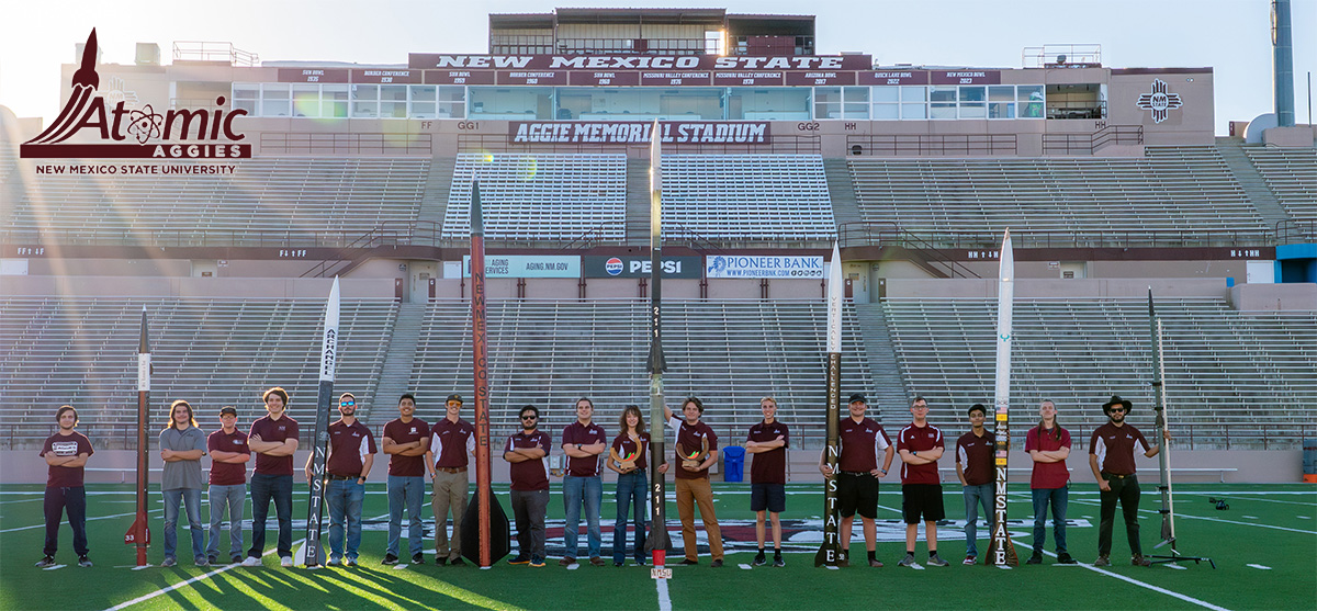 Atomic Aggies rocketry team standing next to each rocket.